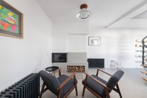 A modern living room with a fireplace, a television, and a bookshelf. - Le Blanc-Meix - 4 guests - Charming house near the lake (Gérardmer)