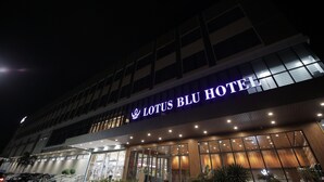 The exterior of the Lotus Blu Hotel with a prominent illuminated sign, large windows, and a modern architectural design. - LOTUS BLU HOTEL NAGA (Naga)