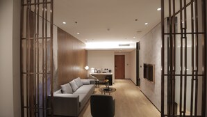 A modern living room with a sofa, a coffee table, and a TV mounted on the wall. - LOTUS BLU HOTEL NAGA (Naga)