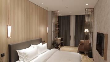 Een moderne hotelkamer met een groot bed, nachtkastje en een bureau met stoel.