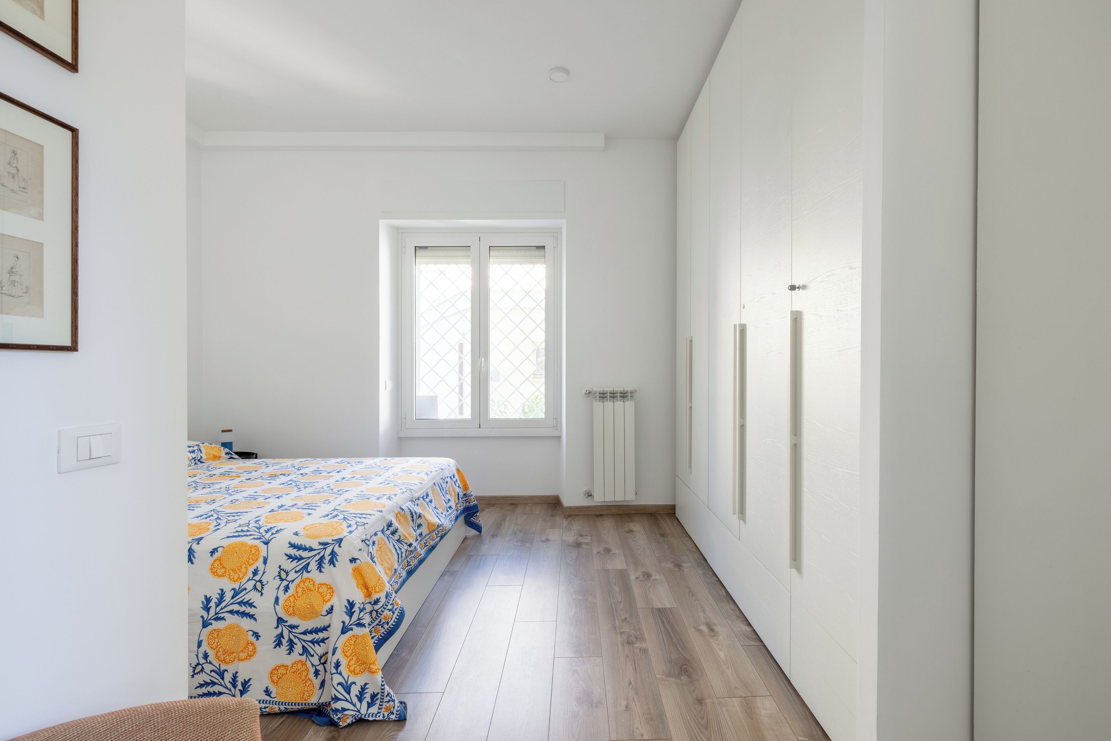 A bedroom with a bed, a window, and a radiator.