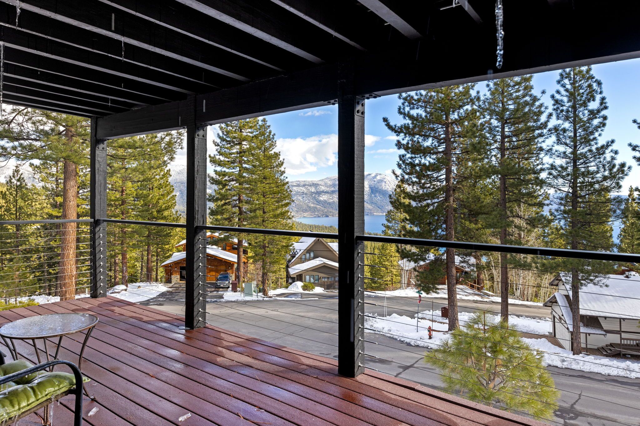 Una terraza de madera con vistas a un paisaje nevado y casas.