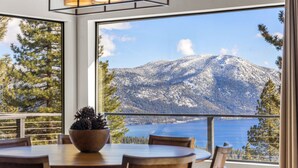 Un espace repas offrant une vue sur une montagne enneigée et un lac.