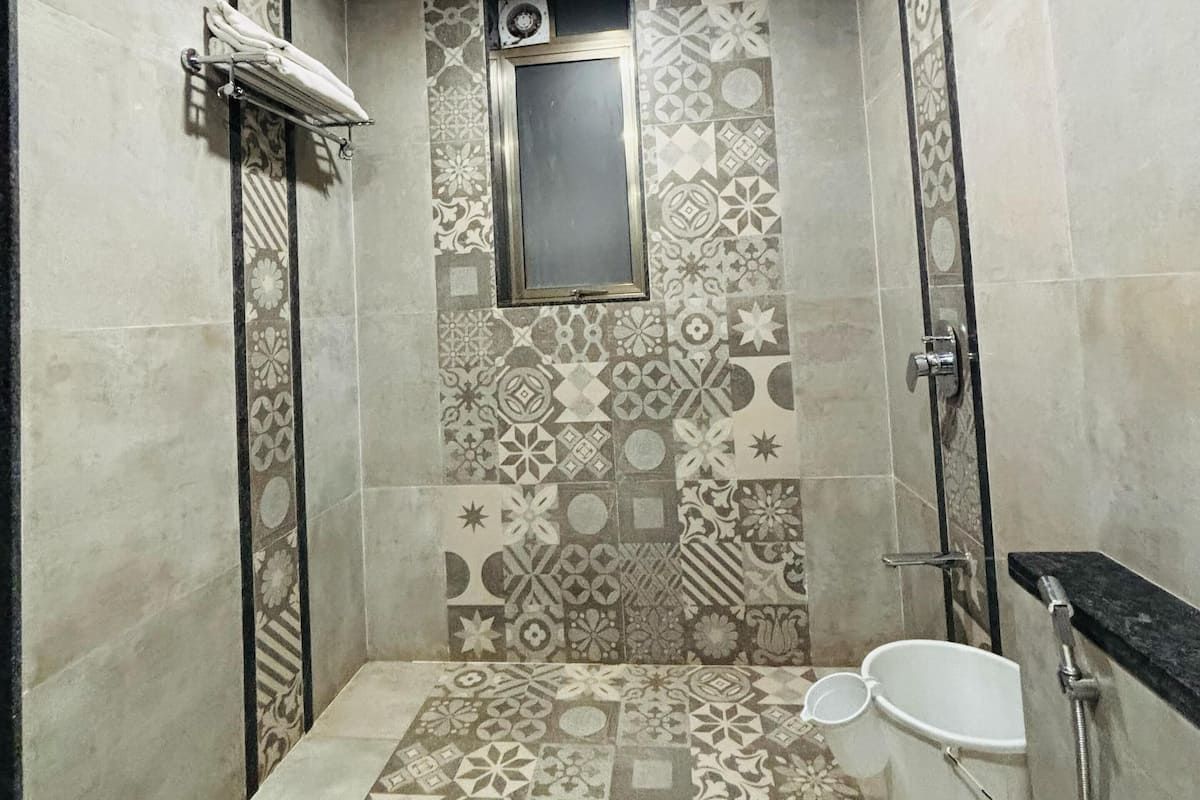 A bathroom with a shower, toilet, and a towel rack.
