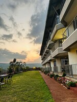 Un hôtel doté d’un balcon donnant sur un espace verdoyant et offrant une vue sur la mer.