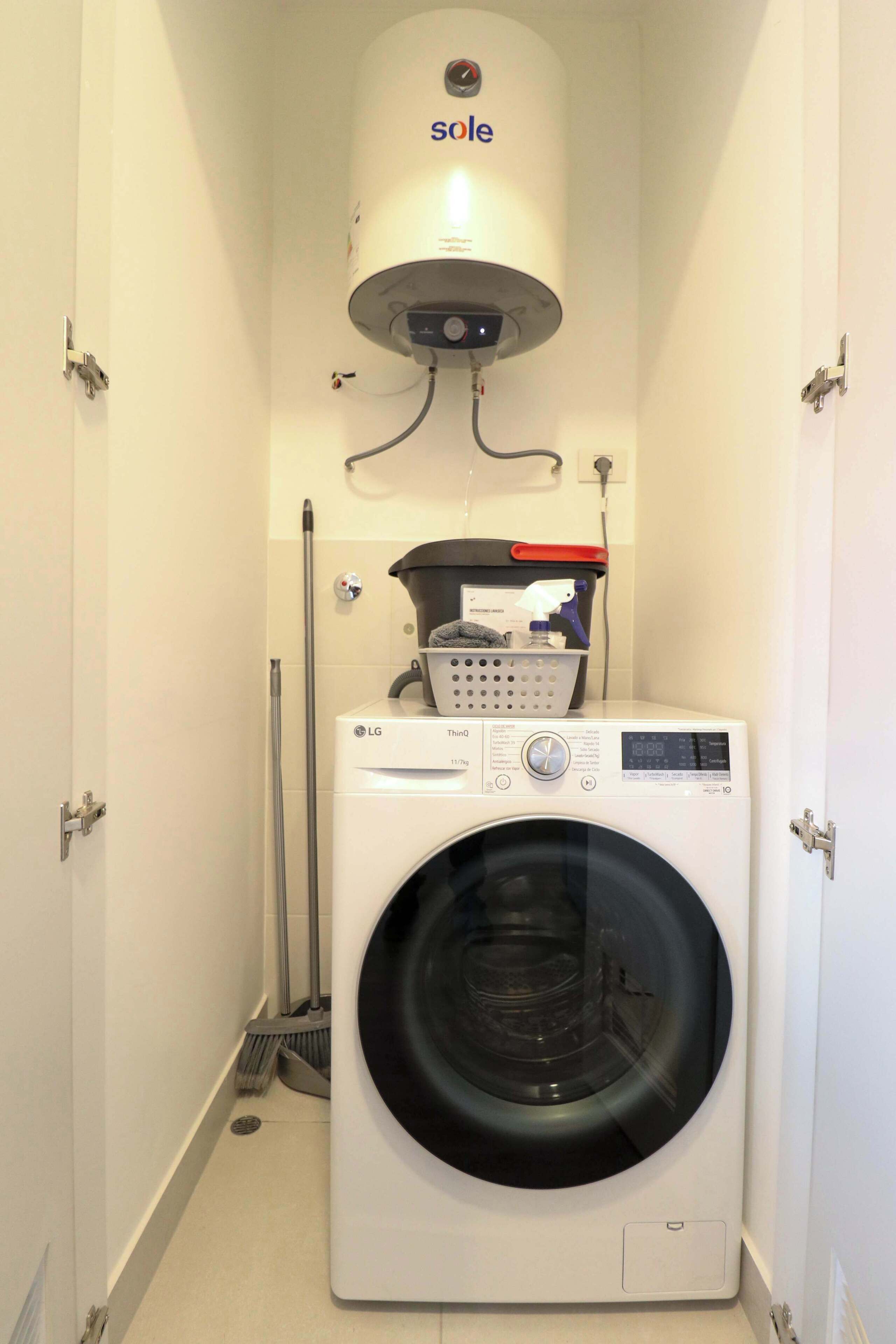 Un cuarto de lavado con lavadora, secadora y calentador de agua.