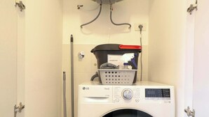 Une buanderie équipée d’un lave-linge, d’un sèche-linge et d’un chauffe-eau.