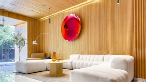 A modern living room with a sectional sofa, a round coffee table, and a red spherical object on the wall. - w* | Wonderful Loft w/ Balcony in Roma Norte (Ciudad de México)