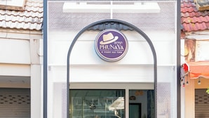 A building with a sign reading "PHUNAYA" and a modern entrance with a glass door. - Phunaya Phuket Oldtown Hotel - SELF CHECK IN (Phuket)