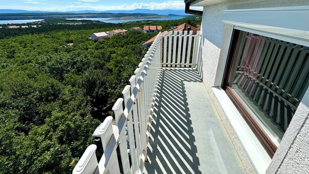 Uma varanda com vista para um lago e montanhas.