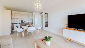 A modern apartment with a dining area, kitchen, and living room.