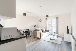 Ein modernes Apartment mit Küche, Essbereich und Wohnzimmer.