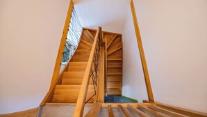 Una escalera de madera con barandilla de metal que conduce a una plataforma.