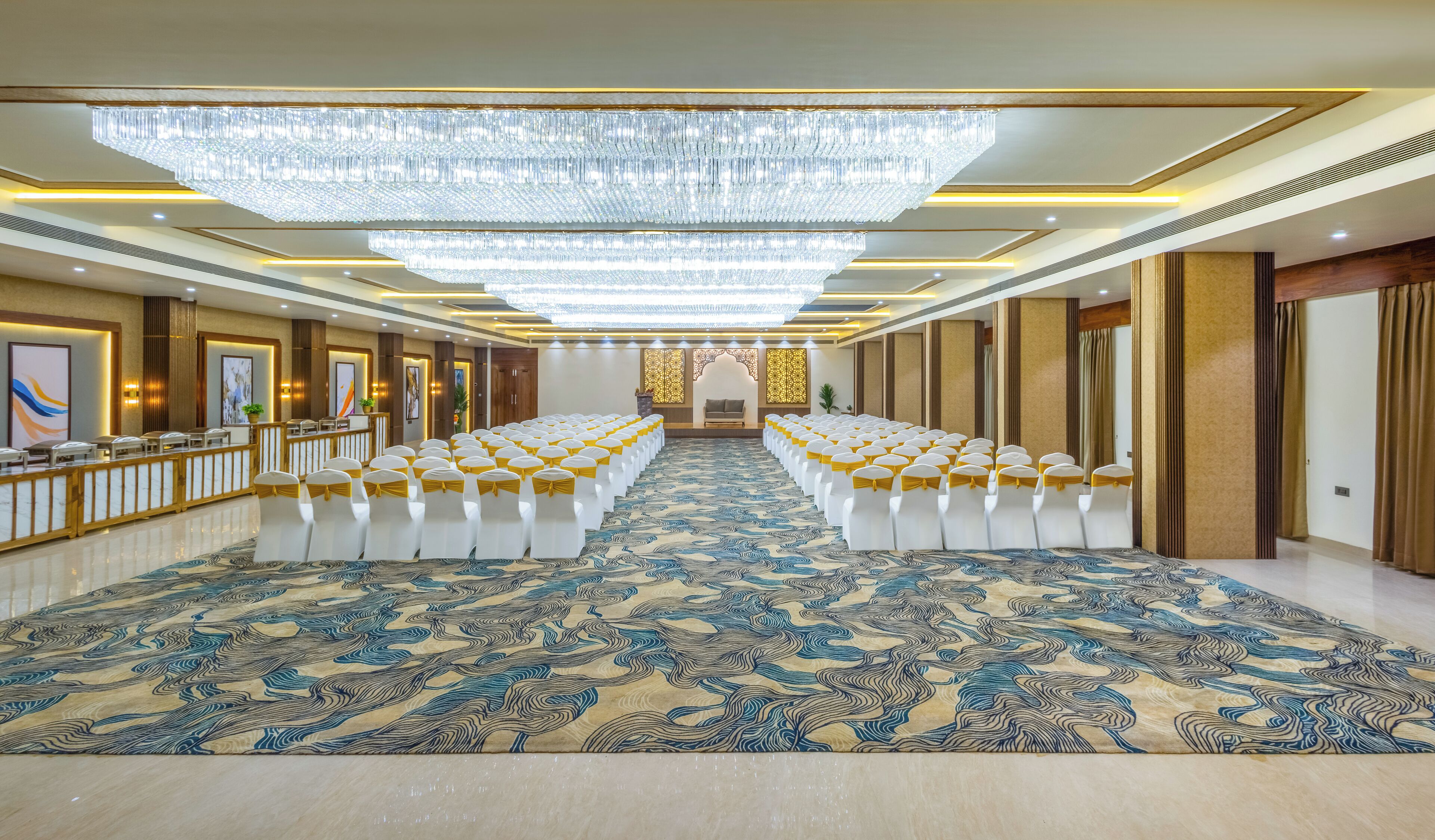 A large, well-lit conference room with rows of white chairs and a patterned carpet.