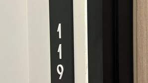 A close-up of a black and white door with the number 119 visible. - Fulmar Pasteur (Bandung)
