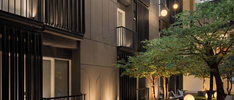A modern building with a courtyard, a water feature, and a tree.