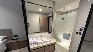 A modern bathroom with a large mirror, a sink, and a shower. - Fulmar Pasteur (Bandung)