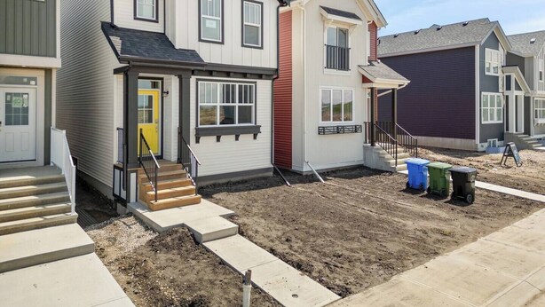 A residential building with a two-story structure, a front porch, and a visible staircase leading to the entrance. - 1BR Lower Level Suite with Secure Entry & Laundry (Calgary)