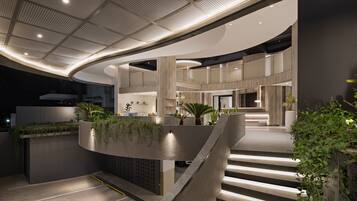 A modern interior with a curved staircase, a reception area, and a ceiling with a perforated design.