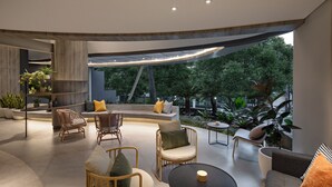 Ein moderner Außenbereich mit gewölbter Decke, Sitzgelegenheiten und Blick ins umliegende Grün.