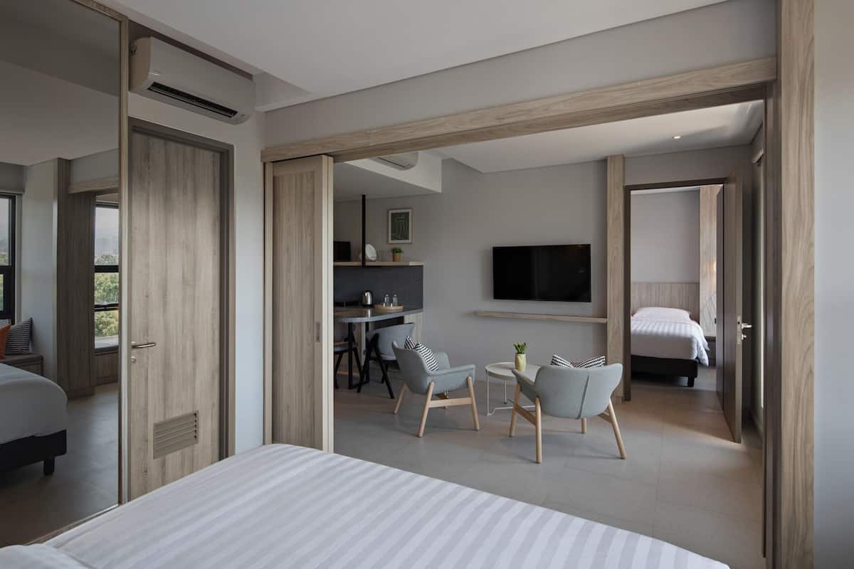 A modern hotel room with a large bed, a desk, and a TV.