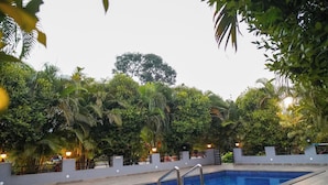 A rectangular swimming pool with a metal ladder, surrounded by a tiled deck. - Vanah Villa And Resort (Mawal)