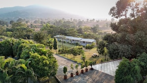 A hotel with multiple rooms, a garden area with potted plants, and a view of the surrounding landscape. - Vanah Villa And Resort (Mawal)
