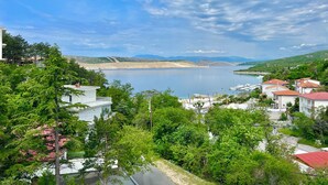 A coastal town with buildings, a bridge, and a calm sea. - Apartman Velly  (Jadranovo)