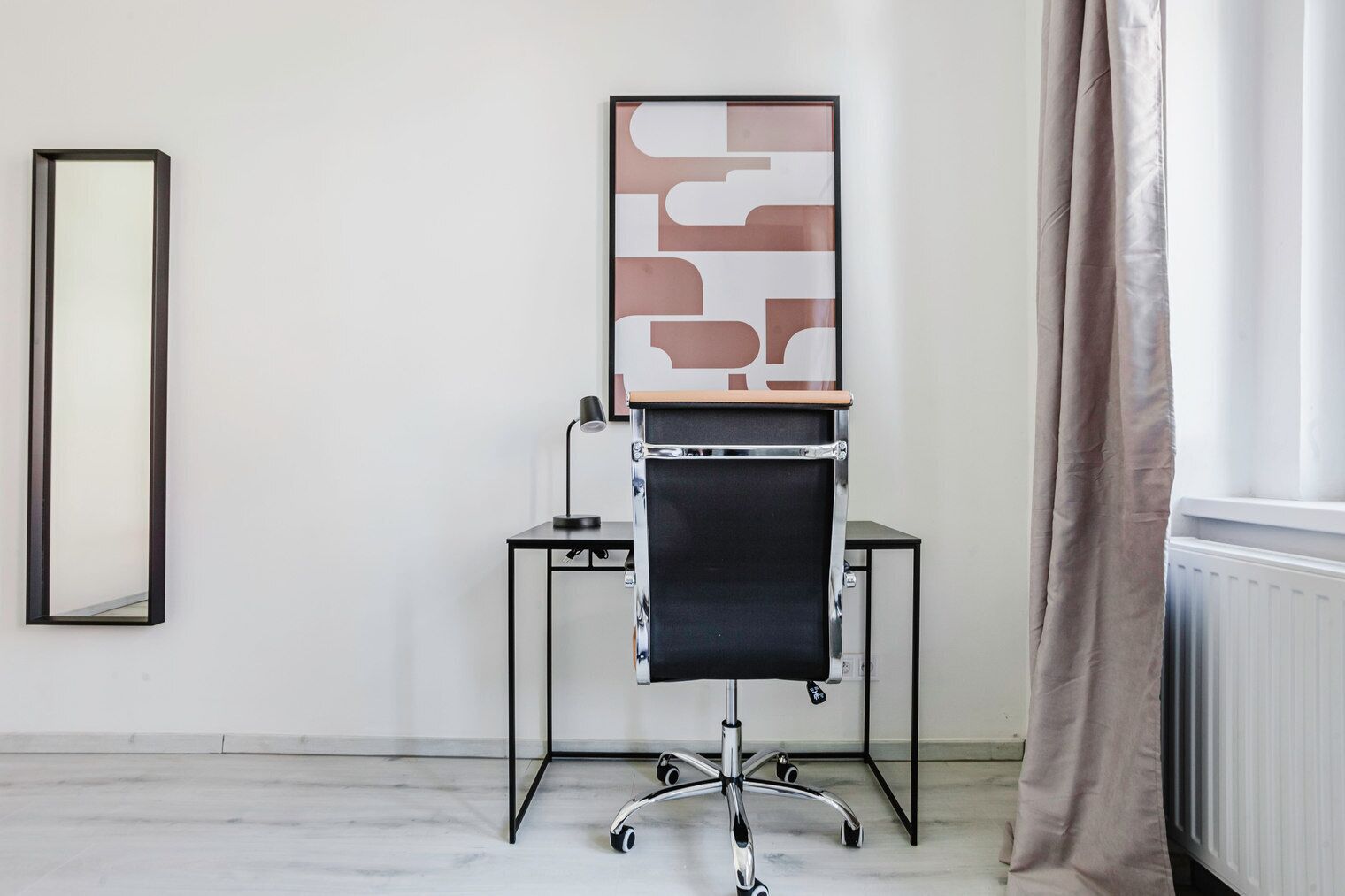 Ein moderner Büroraum mit Schreibtisch, Stuhl und einem großen abstrakten Kunstwerk an der Wand.