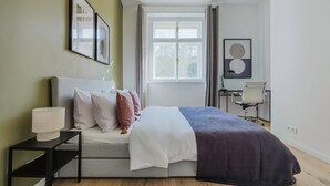 A modern bedroom with a bed, bedside table, lamp, and artwork. - Blueground | Prague 3, close to offices & mall (PRG-20) (Prague)
