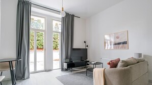 En moderne stue med en sofa, et fjernsyn og et bord.