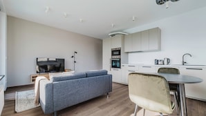 Ein modernes Apartment mit Wohnbereich, Küchenzeile und Essbereich.