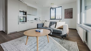Eine moderne Wohnung mit Küche, einem grauen Sofa und einem Couchtisch.