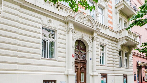 Un edificio storico con dettagli architettonici elaborati, tra cui un ingresso ad arco ben visibile e modanature decorative.