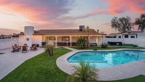 A backyard with a swimming pool, outdoor seating, and a covered patio area. - The Ridge: Family | Pickleball | Pool | Hot Tub (Phoenix)