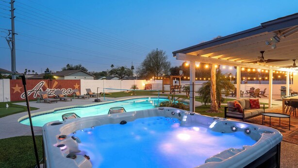A backyard with a swimming pool, hot tub, outdoor seating, and a covered patio area. - The Ridge: Family | Pickleball | Pool | Hot Tub (Phoenix)