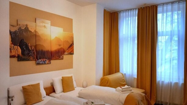 Habitación de hotel con dos camas, un cuadro grande en la pared y una ventana con cortinas.