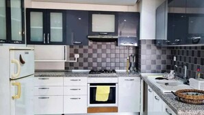 A modern kitchen with white cabinets, a gas stove, and a microwave.
