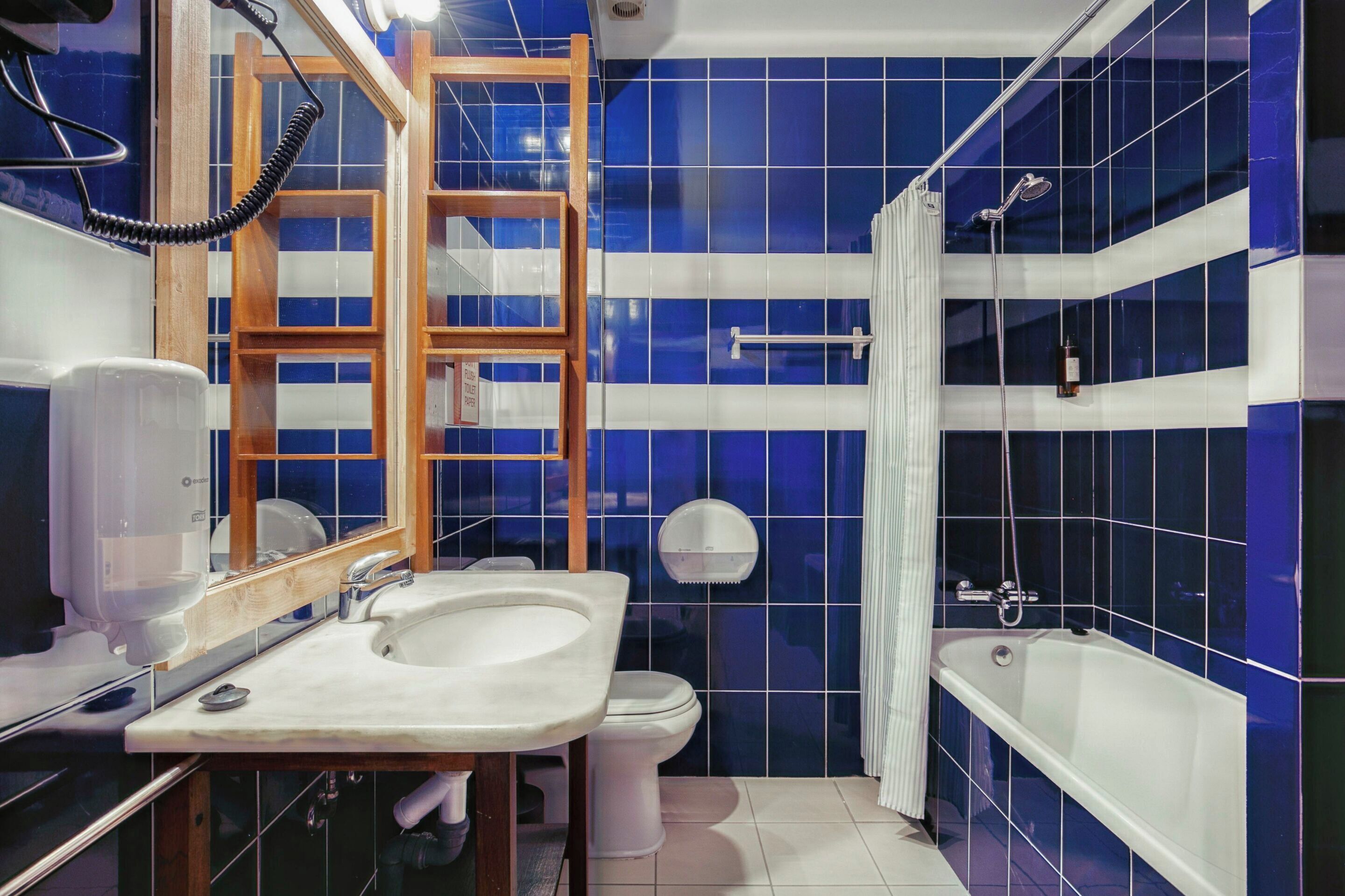 Un baño con lavamanos, inodoro y bañera.