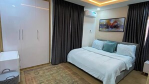Quarto moderno com uma cama grande, um guarda-roupa, uma escrivaninha e um tapete.