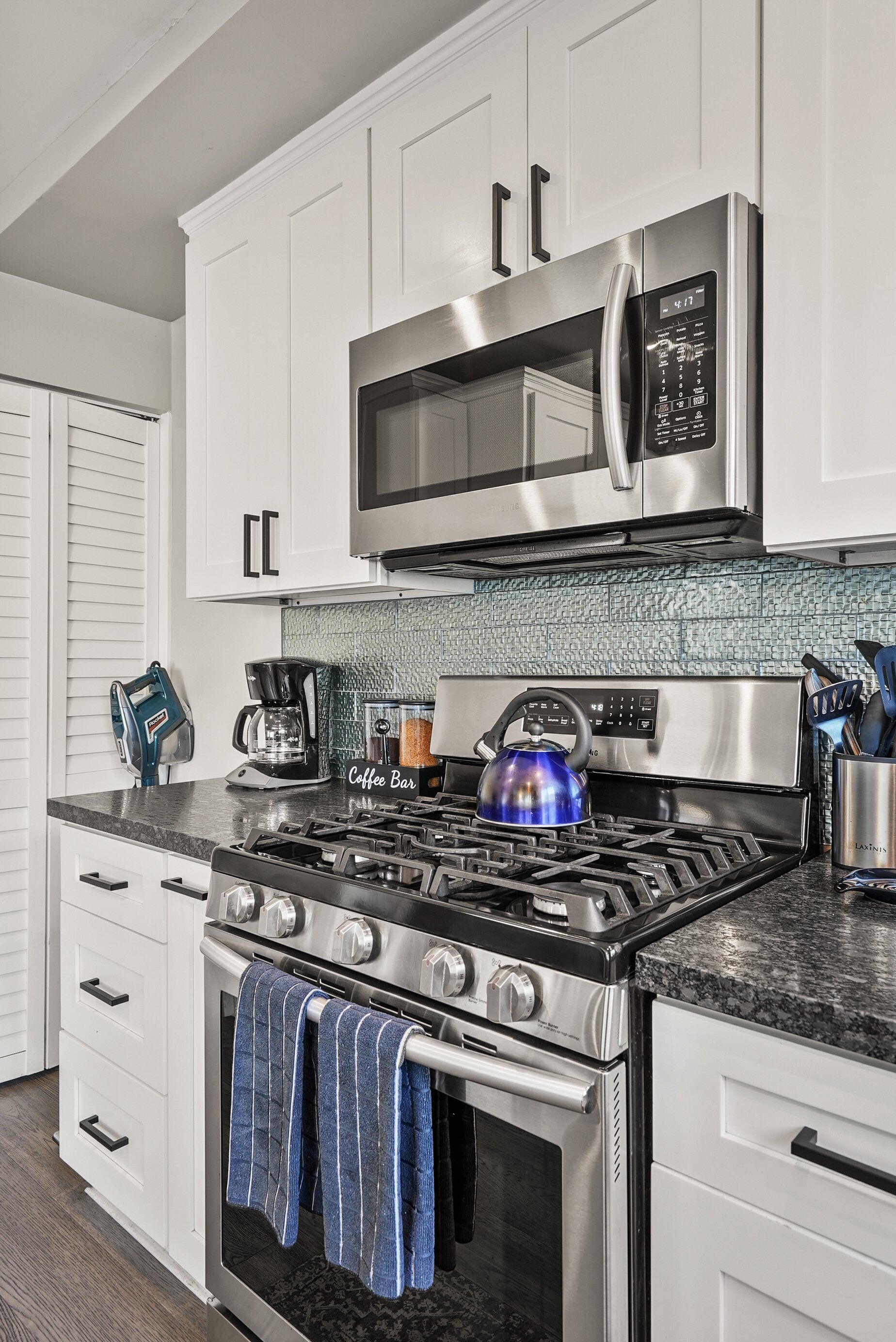 Una cocina moderna con electrodomésticos de acero inoxidable, cafetera y hervidor.