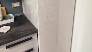 A modern kitchen with a built-in refrigerator, a dark countertop, and a white sink. - BLUE SEA..... YOUR DREAM VACATION! (Avola)