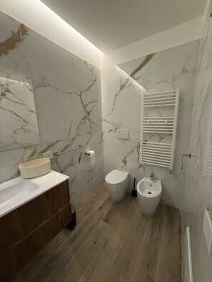 Een douche, een haardroger, een bidet, handdoeken
