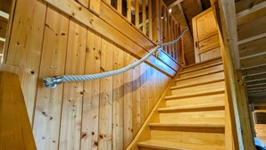 A wooden staircase with a rope handrail and wooden walls. - Spacious chalet in La Bresse, perfect for families and friends (La Bresse)