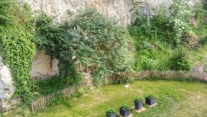 A garden with a wooden fence, a grassy area, and potted plants. - Charming Touraine cottage with spa and private garden (Saint-Germain-sur-Vienne)