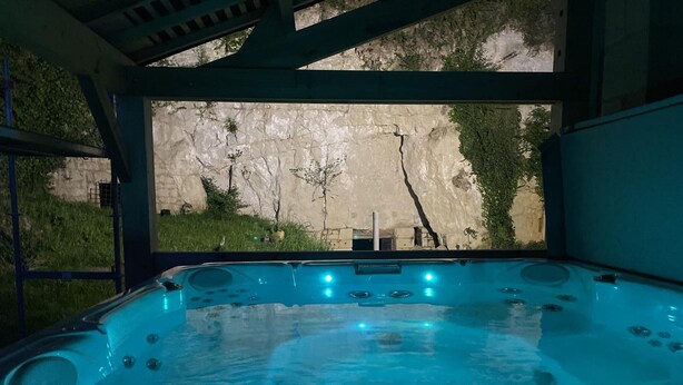 A hot tub with a digital control panel, surrounded by a stone wall and greenery. - Charming Touraine cottage with spa and private garden (Saint-Germain-sur-Vienne)