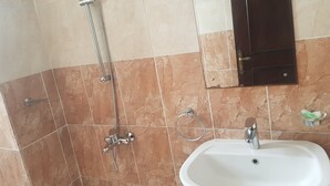 Ein Badezimmer mit Dusche, Waschbecken und Spiegel.