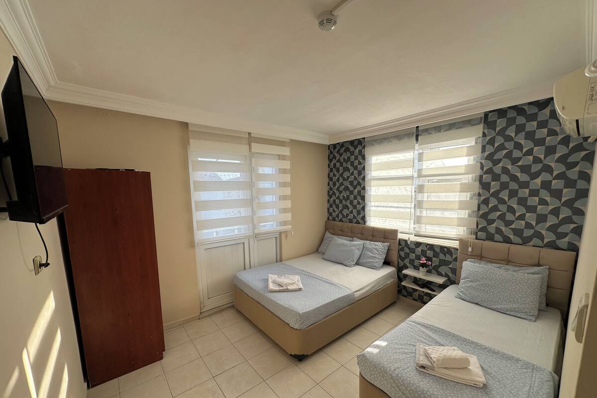 A hotel room with two beds, a TV, and a wardrobe.