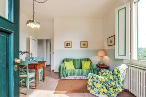 Una habitación con cama, una silla, una mesa y una ventana.