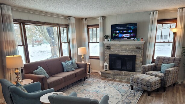 Una sala de estar acogedora con sofá, sillones, chimenea y televisión.